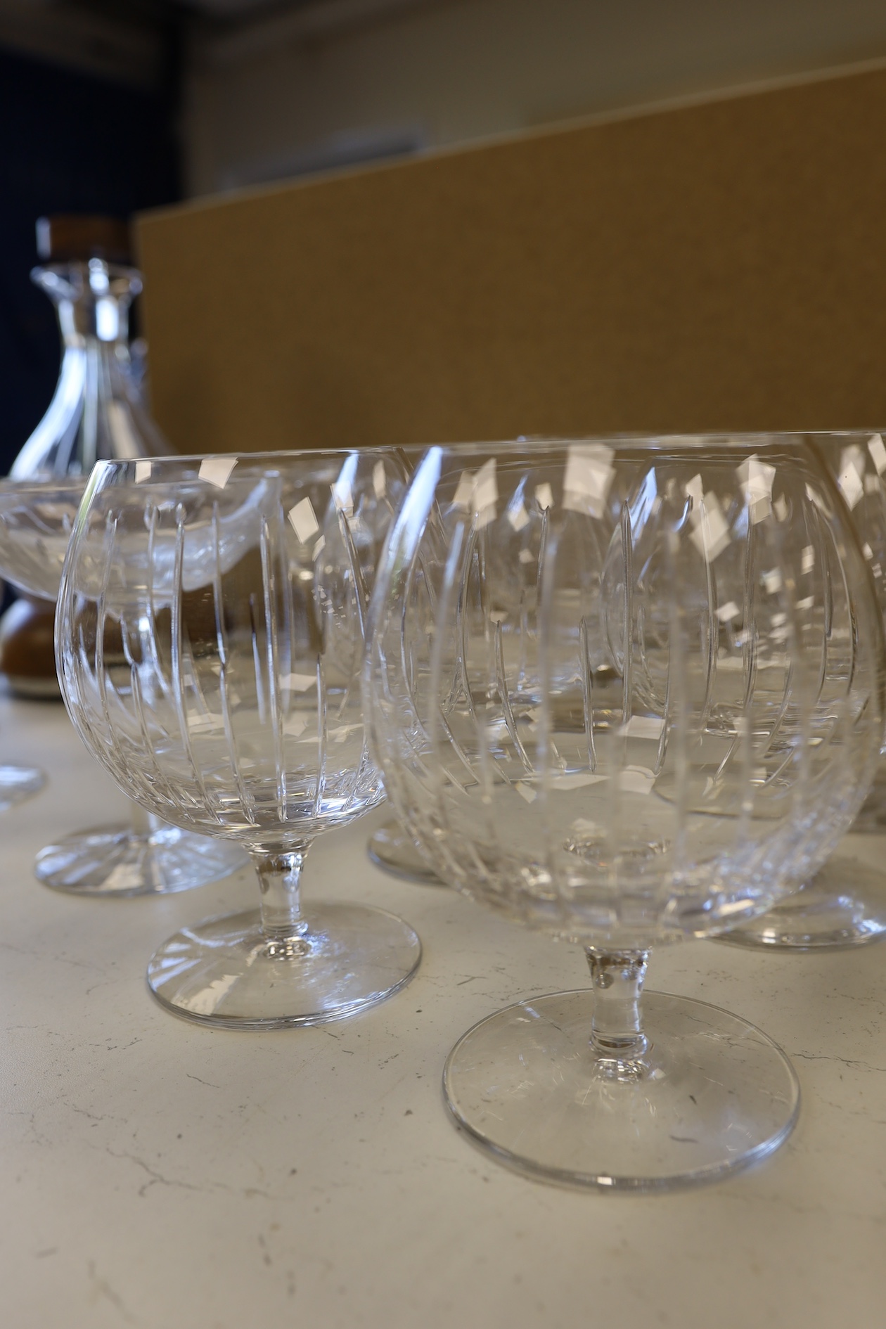 A Linley Glyndebourne pattern cut glass decanter with a silver mounted stopper, on a weighted wooden coaster stand, and a matching set of ten goblets, and eight champagne coupes, largest 30cm high. Condition - all in ver